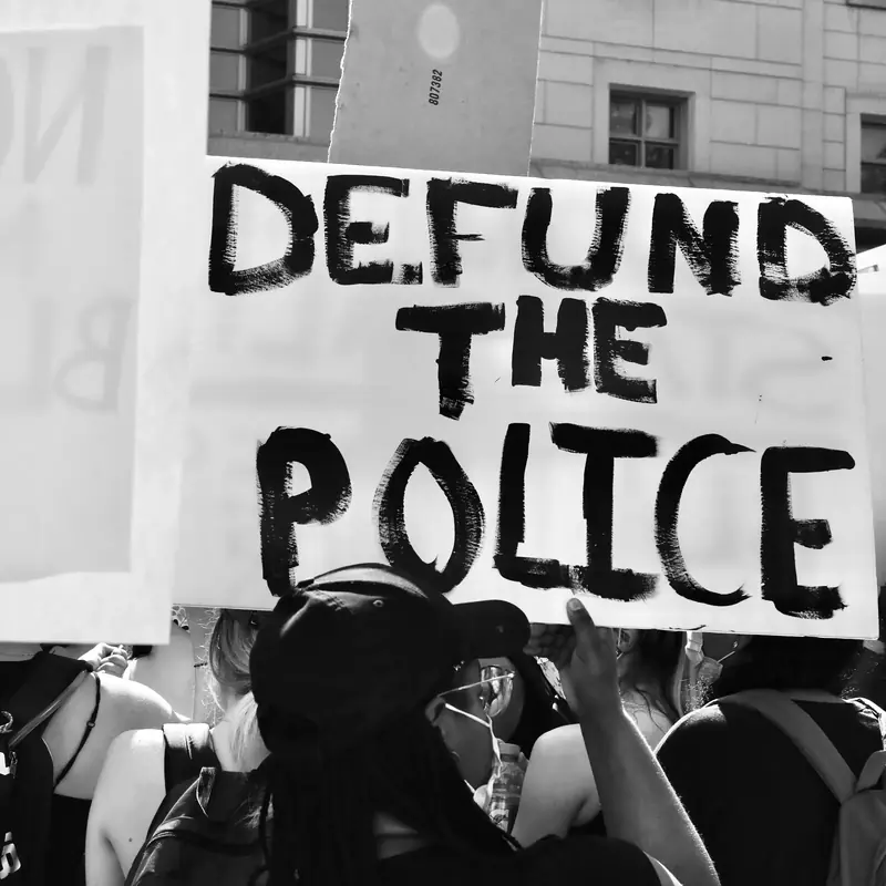A 2020 demonstrator holding a Defund the Police sign